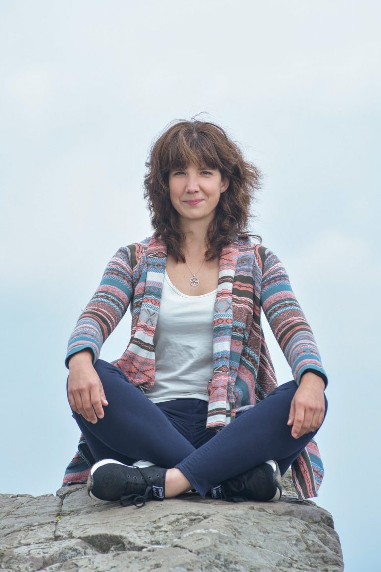 Dr. Ann-Christin Frank - Gründerin von LebensFunkeln Poträt einer lächelnden Frau in der Natur, offene, herzliche Ausstrahlung vor grünem Hintergrund. LebensFunkeln - Persönlichkeitsentwicklung